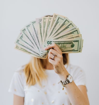 Woman Holding Fan of US Dollar Bills