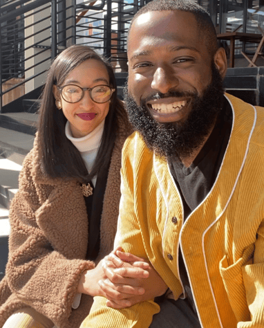 a man and woman sitting on stairs smiling