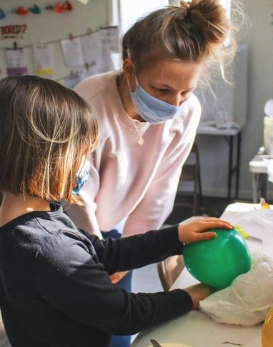 Young teen helping a youth student with her project.