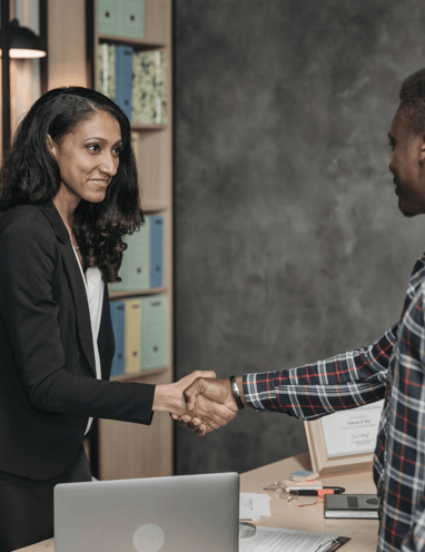 a man and woman shaking hands in a meeting room