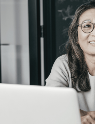 a woman sitting at a table with a laptop