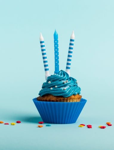 a cupcake with blue icing and candles