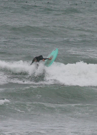 Surfer on green board performing a vertical snap