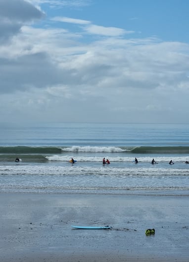 Clean waves breaking at Ynyslas with a surf lesson.