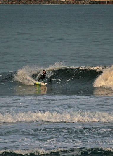 A surfer doing a forehand cutback in the early morning sun.