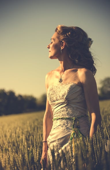 a woman in a white dress standing in a field