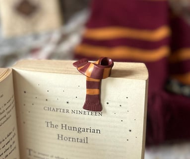 red and yellow gryffindor scarf bookmark made of clay kept on a harry potter book