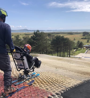 a man in a helmet and skis on a dry ski slope