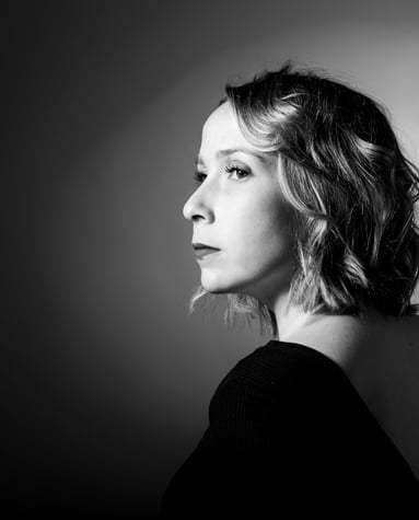Photo en noir et blanc d'une femme de profil sur fond noir avec halo