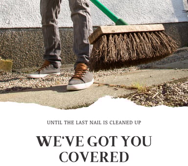 A worker sweeping up a job site at the end of a job in jeans and sneakers