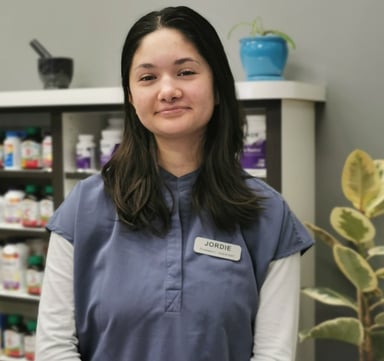 picture of woman with dark hair wearing blue scrubs