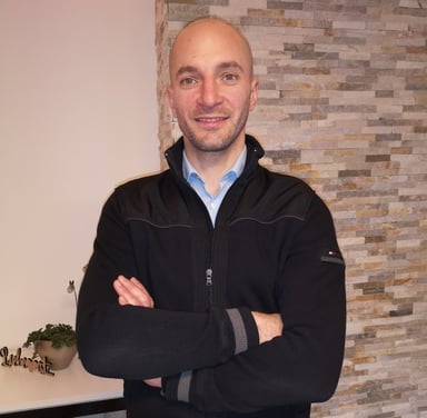 a man in a black jacket and a blue shirt