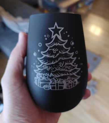 Schwarzes Glas, in der Hand gehalten, mit einem Weihnachtsbaum und Geschenke Motiv