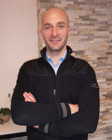 a man in a black jacket and a blue shirt