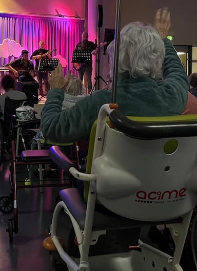 Photo de Magali STrassel, art-thérapeute, montrant une personne agée apprécier un concert