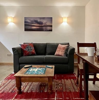 a sofa table and chair in a room with a colourful rug