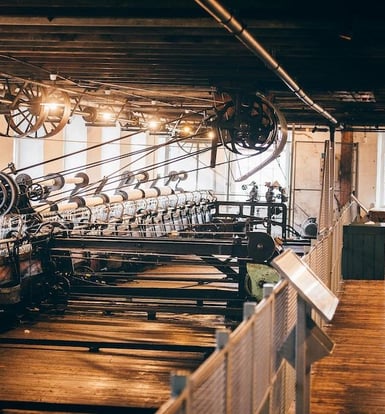 A large number of old weaving machines in a mill