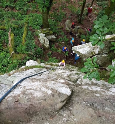 a group of people climbing up a mountain with ropes