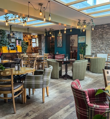 A restaurant with a skylight and tables and chairs