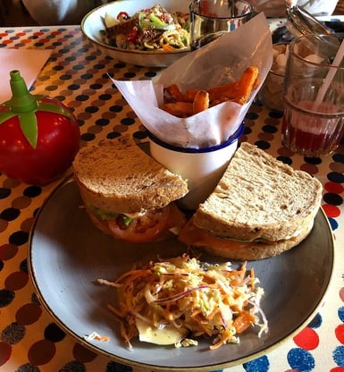 A sandwich with fries and a salad