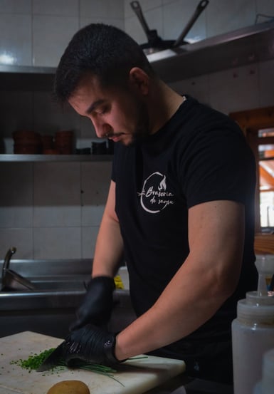 a man in a black shirt is cutting up some vegetables