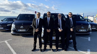 a group of men in suits and ties standing in front of a car