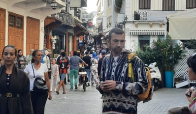 Tanger morocco a man walking down a street with people walking by