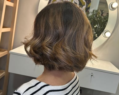 a woman with a short haircut and a balayage color