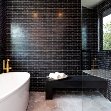 black brick luxury bathroom showing a couple towels and bathtub