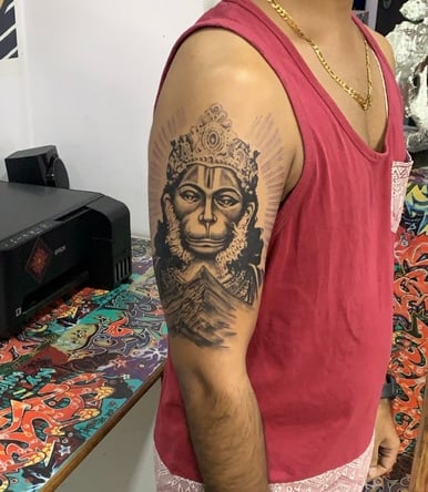 Realistic Hanuman face tattoo in black and grey on shoulder by Dudo’s Tattoos in Hyderabad