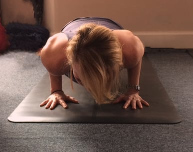 a woman doing a yoga pose on a mat