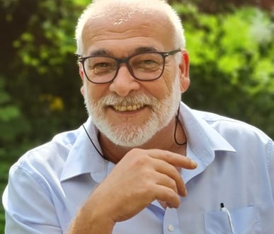 Patrick Beiner with a beard and glasses sitting in a chair