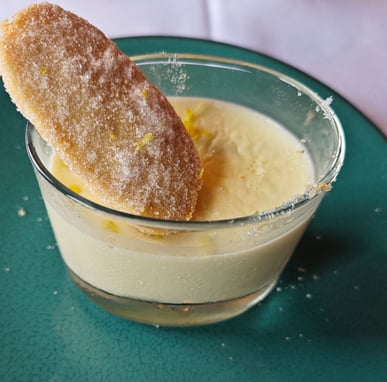 Lemon flavoured dessert with biscuit on green plate