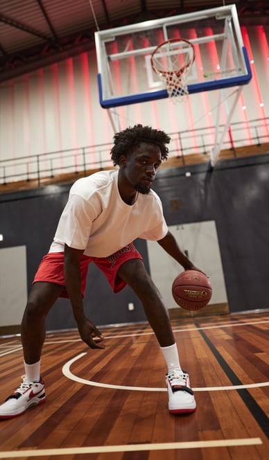 Fashion photography - a man in a white shirt and red shorts playing basketball