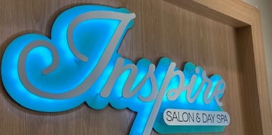 Inspire Salon and Day Spa logo sign displayed above the reception desk is stylish and relaxing.