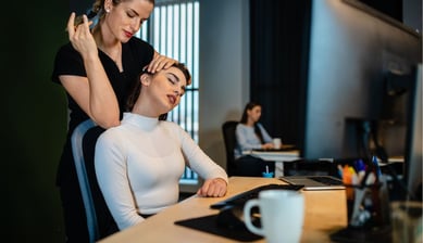 a busy professional getting a massage at her desk by a Remedly physio