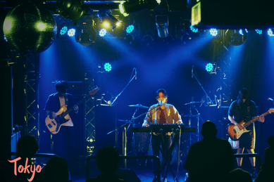 a man playing a guitar on stage with a band