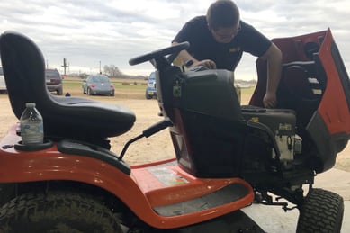 a man working on a riding lawn mower