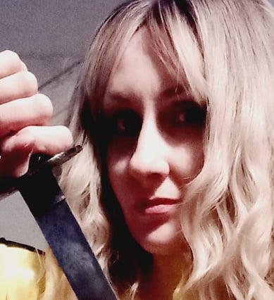 Kill Bill in a yellow jacket holding a katana and a knife