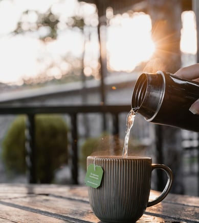 pouring water into a cup of tea