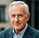 Older man with gray hair in blazer outdoors. Trusted Cedar Rapids testimonial for tech handyman help.