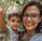 a woman holding a child and giving a peace sign