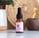 A dropper bottle of Souaad's prickly pear seed oil set in front of other skincare tools and wicker basket