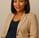 a pregnant woman in a tan blazer and black top