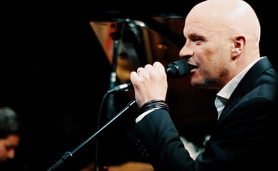 a man in a suit and tie is singing into a microphone