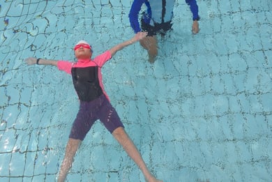 child learning backfloat at bishan swimming complex