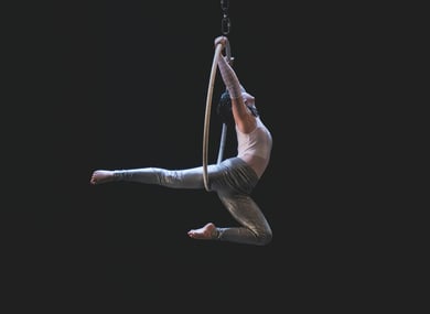 A man dancing on an aerial hoop
