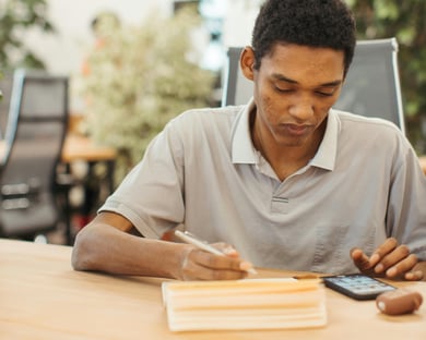 a man sitting at a table with a cell phone