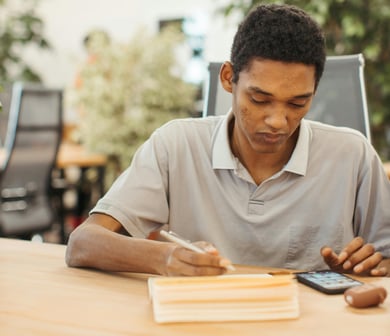 a man sitting at a table with a cell phone