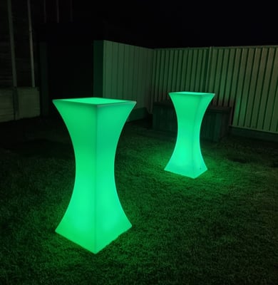 Green glowing cocktail tables in the back yard of an event in Redlands.